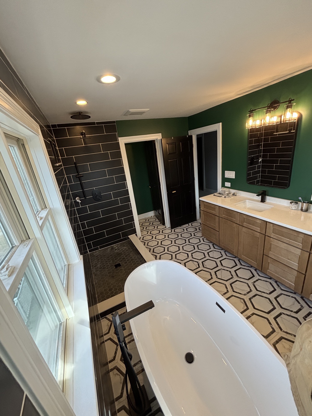 View across the freestanding tub toward the double vanity and walk-in shower